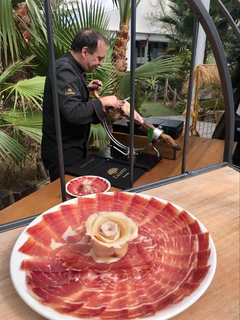 Lázaro Ortega cortando jamón en un evento